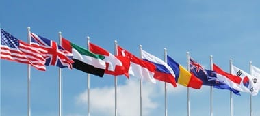 National flagpoles of different countries next to each other.